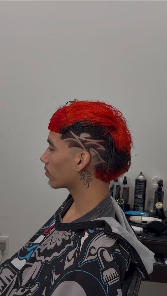 Red and black mullet with a tribal design shaved into the side